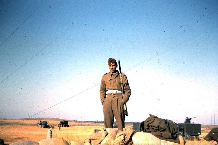 A Libyan Army guard stands watch as missiles are prepped in the background